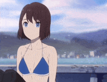 a girl in a blue bikini with blue eyes is looking at something