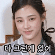 a close up of a woman 's face with a ponytail and korean writing on it .