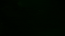 a green light beam is coming out of a dark background