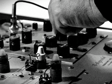 a black and white photo of a person adjusting a polygrite electronic device