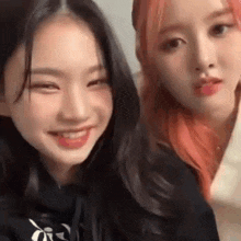 two girls with red hair are smiling for the camera .