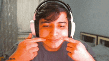 a man wearing headphones is making a face with his hands