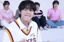 a group of young men are sitting on the floor and one of them has a name tag that says yps on it