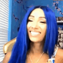 a woman with blue hair is smiling in front of a window .