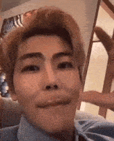 a close up of a man making a funny face while sitting on a couch .