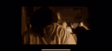 a blurry picture of a person standing in front of a window in a dark room .