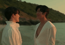two men in white shirts are looking at each other