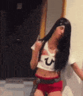 a woman wearing a crop top and red shorts is dancing .