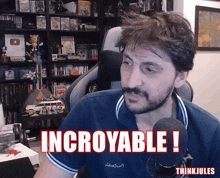 a man sitting in front of a microphone with the words incroyable in red