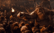 a man with a beard and a crown stands in front of a crowd of animals