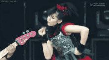a girl in a metal outfit is dancing in front of a tv screen that says tyforce of courage