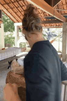 a man with a bun is standing in front of a table