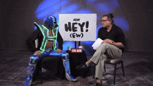 a wrestler sitting in front of a sign that says hey