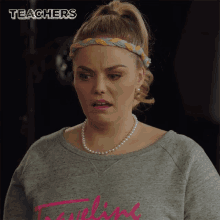 a woman wearing a pearl necklace and a headband with the word teachers above her head