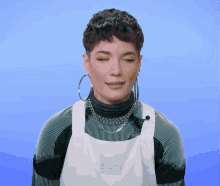 a woman wearing a green and white striped sweater and white apron with a label that says dickies