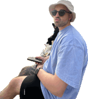 a man wearing a hat and sunglasses holds a cellphone