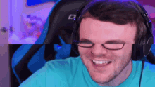 a man wearing glasses and headphones is smiling while sitting in a chair .