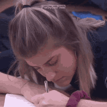 a woman is writing on a piece of paper with the words furbysinpilas above her head