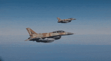two fighter jets are flying in the sky and one of them has a marking on the tail that says ' a '