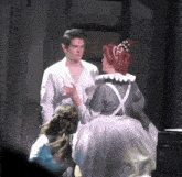 a man in a white shirt is standing next to a woman in a gray dress