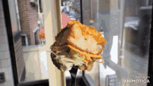 a piece of food on a fork with the words made in animotica on the bottom right