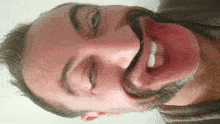a man with a beard makes a funny face with his tongue out
