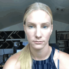 a woman with blonde hair is looking at the camera with a ponytail