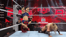 a woman is doing a handstand in a wrestling ring that says raw on it