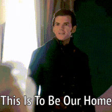 a man is standing in front of a window with the words " this is to be our home " above him