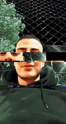 a man in a black hoodie looks at the camera