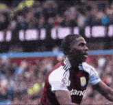 a soccer player wearing a maroon and white jersey with the word stand on the front