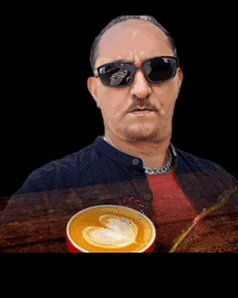 a man wearing sunglasses is holding a cup of coffee with arabic writing on it