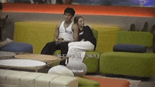a man and a woman are sitting on a yellow couch with the words jarren & fyang written on the bottom