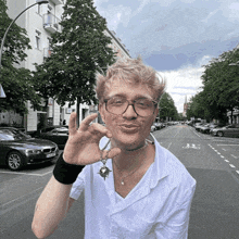 a man wearing glasses and a necklace with a key on it is making a funny face