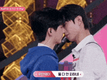 two young men are kissing each other with a sign that says ' i ' on it