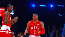 two basketball players are standing next to each other on a court .