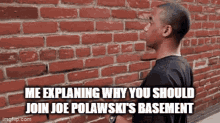 a man is standing in front of a brick wall explaining why he should join joe polawski 's basement