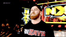 a man with a beard wears a shirt that says wzayn