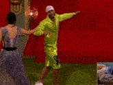 a man in a green shirt is dancing with a woman