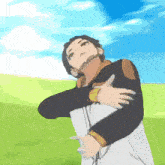 a man in a black and white jacket is hugging his chest in a field