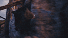 a woman in a black cape is flying in the air