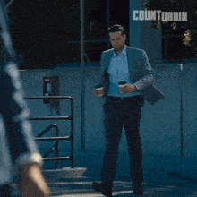 a man holding a gun in front of a countdown sign