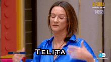 a woman in a blue shirt is giving a thumbs up and says telita on the screen