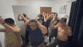 a group of men are dancing in a room and one of them is wearing a shirt that says ' i love you '