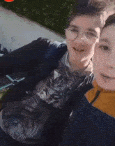 a boy wearing glasses and a shirt with a cat on it poses for a picture