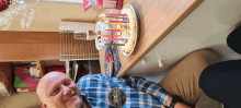 a man in a plaid shirt has a birthday badge on his shirt