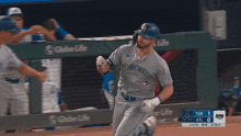 a toronto blue jays player runs towards the dugout