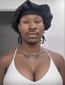 a man wearing a hat and a white tank top
