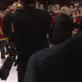 a man in a suit is talking on a cell phone in front of a crowd