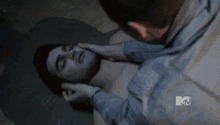 a man is laying on the ground with his head on another man 's shoulder .